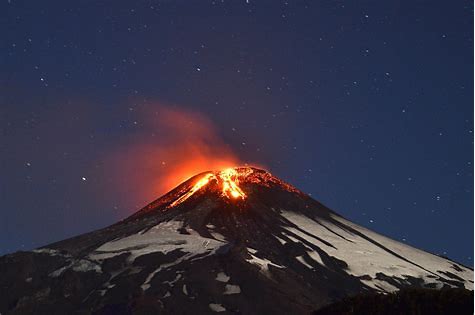 A volcano erupting at night Description automatically generated